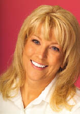 figure 10-Postoperative full-facial view of the author chairside-instead of in the chair-where she can help patients fully understand the benefits of their comprehensive dentistry.