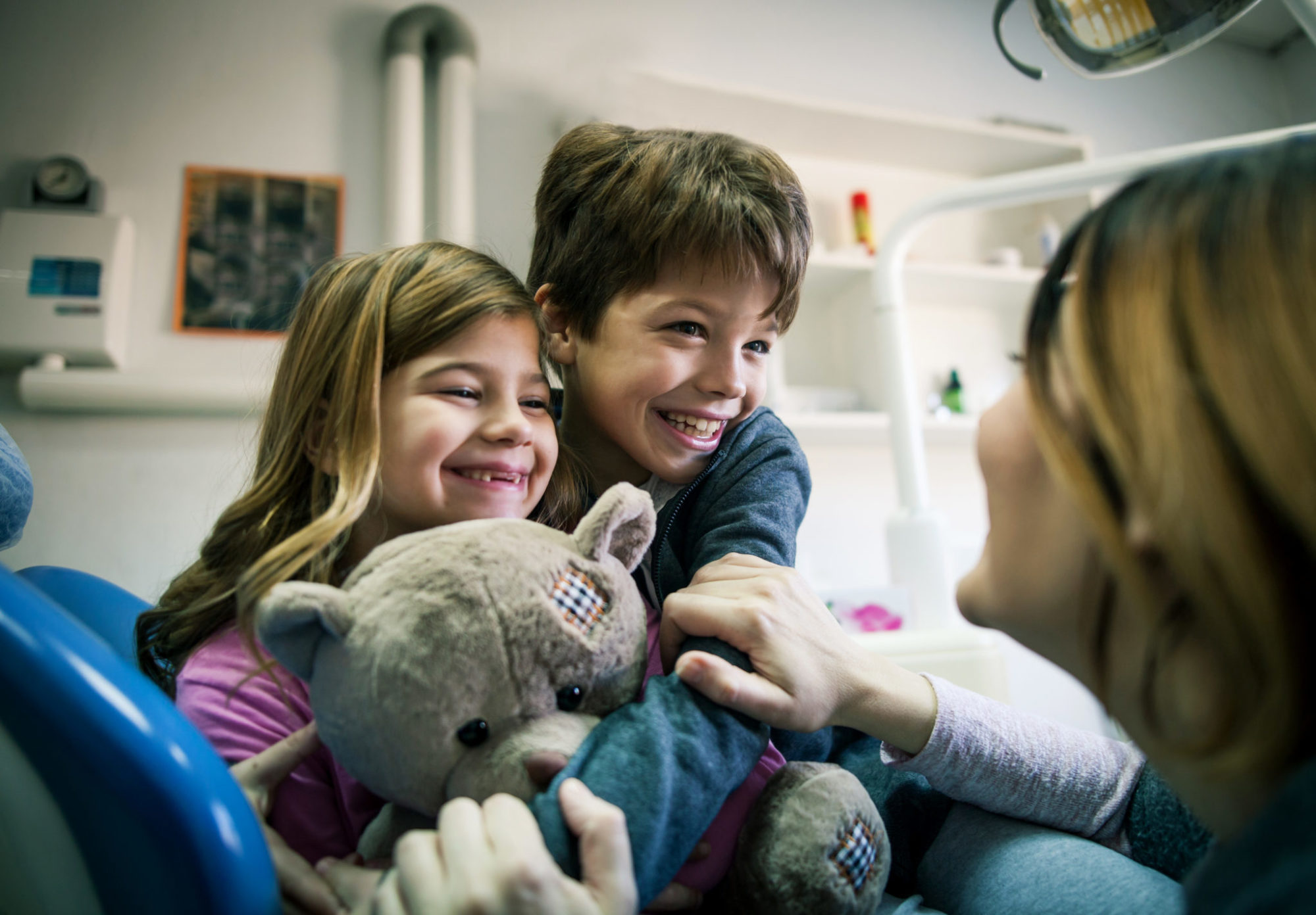 Smiling mother and child  at dental clinic alternate text for this image