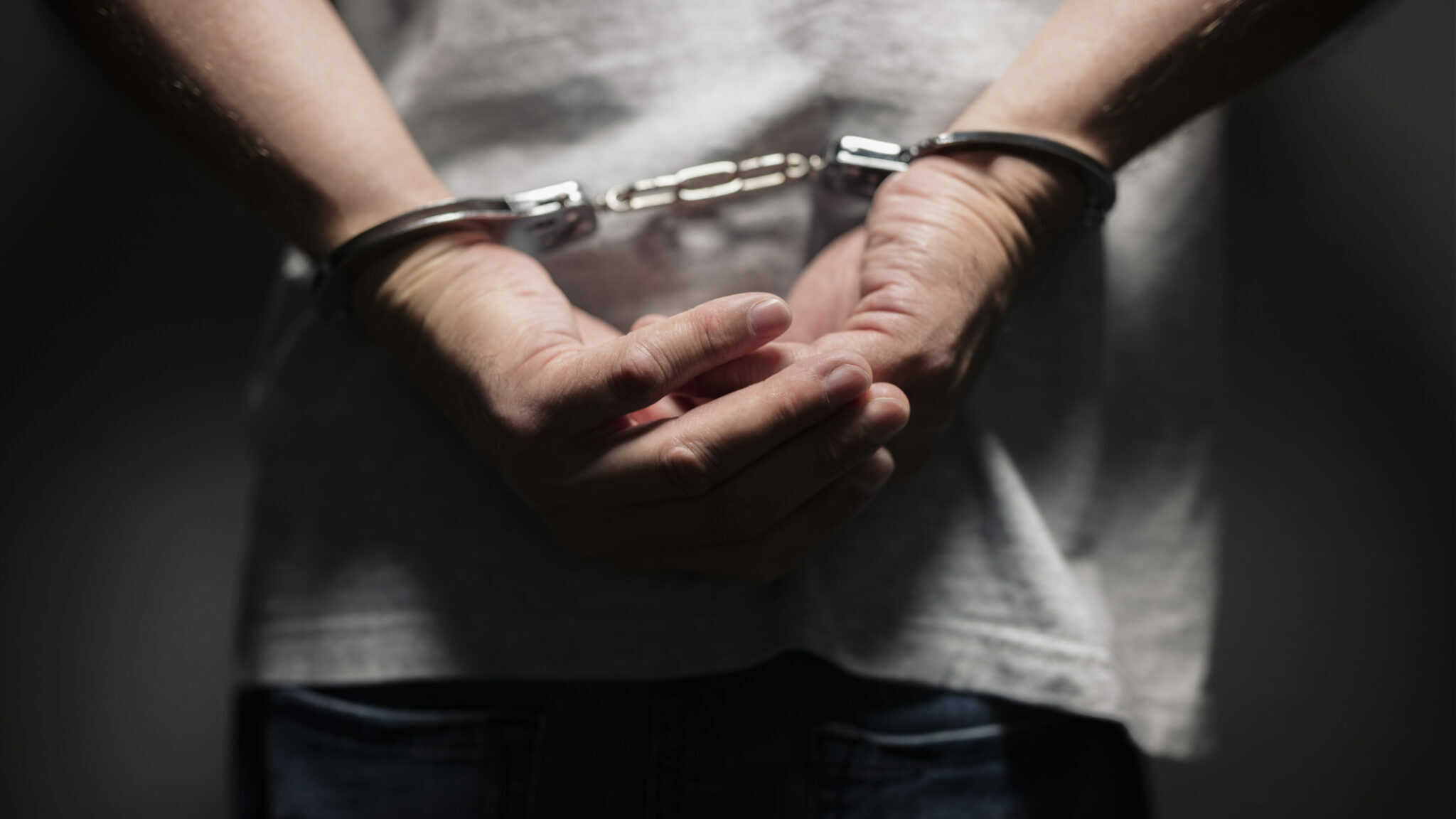 Criminal in handcuffs alternate text for this image