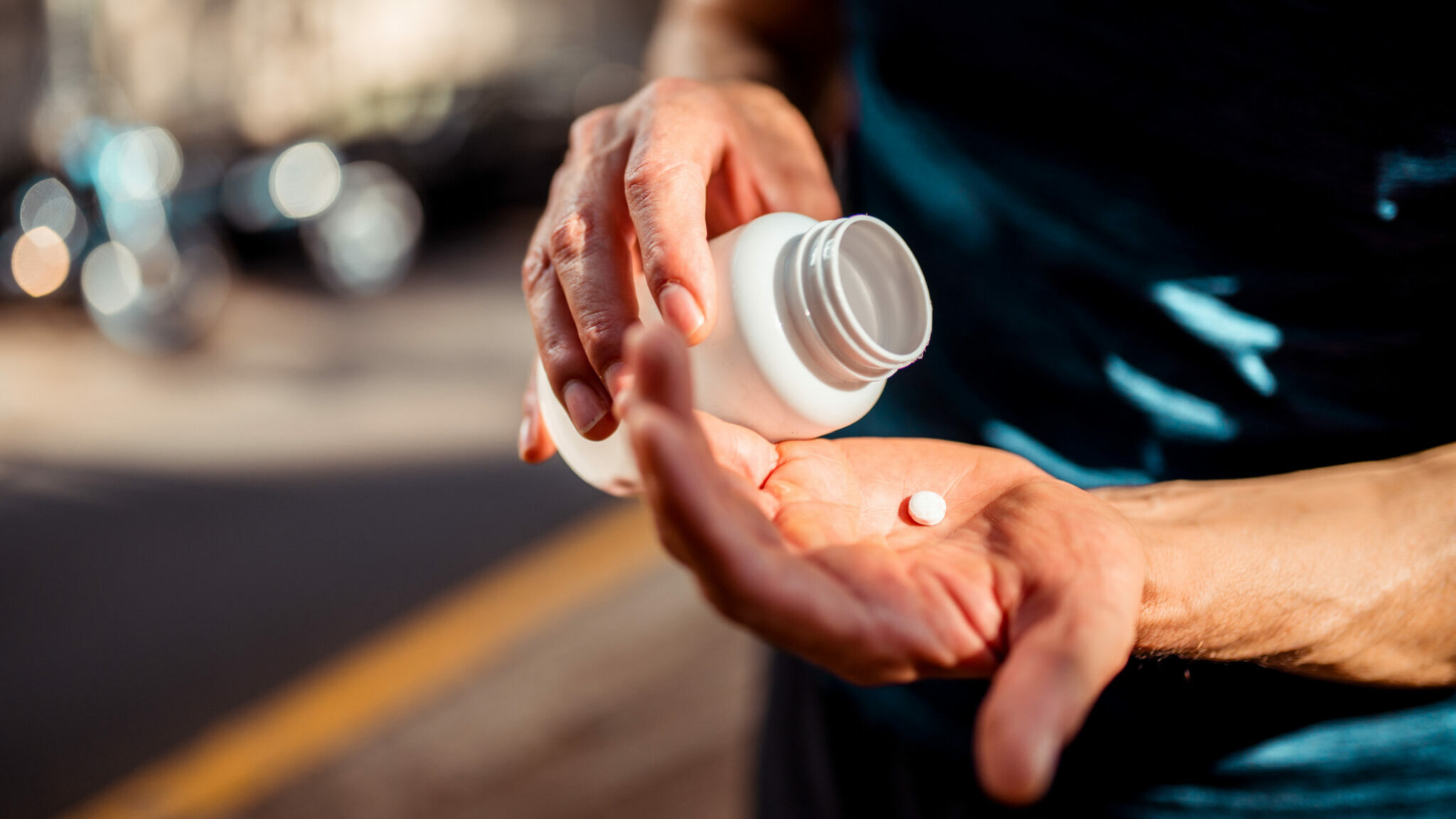 Close up of human hands. He is taking pill alternate text for this image
