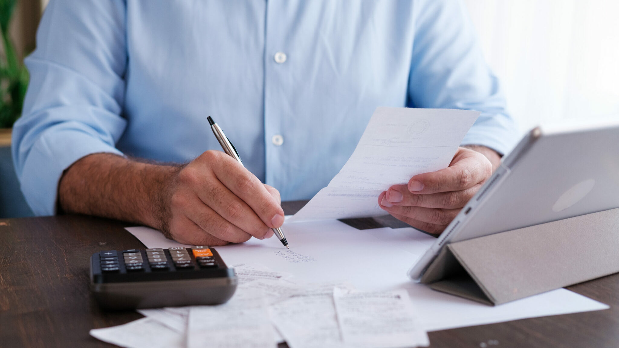 Man calculating personal expenses at home alternate text for this image