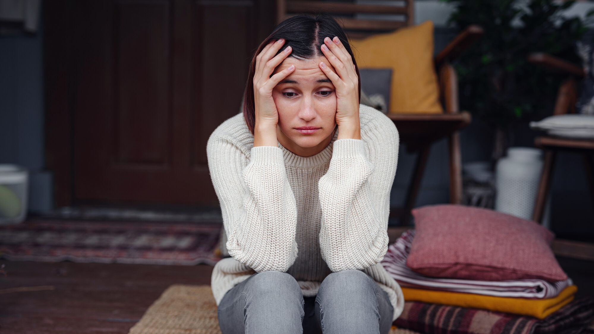 Young depressed asian woman sitting on porch of backyard. alternate text for this image
