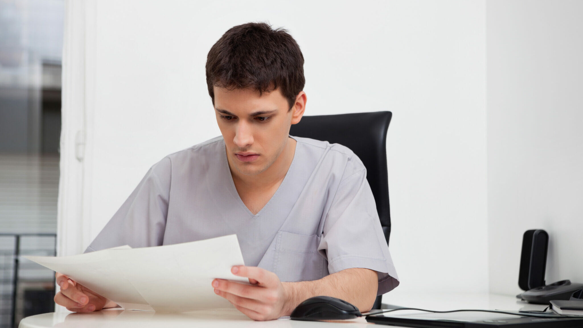 Doctor reading reports alternate text for this image