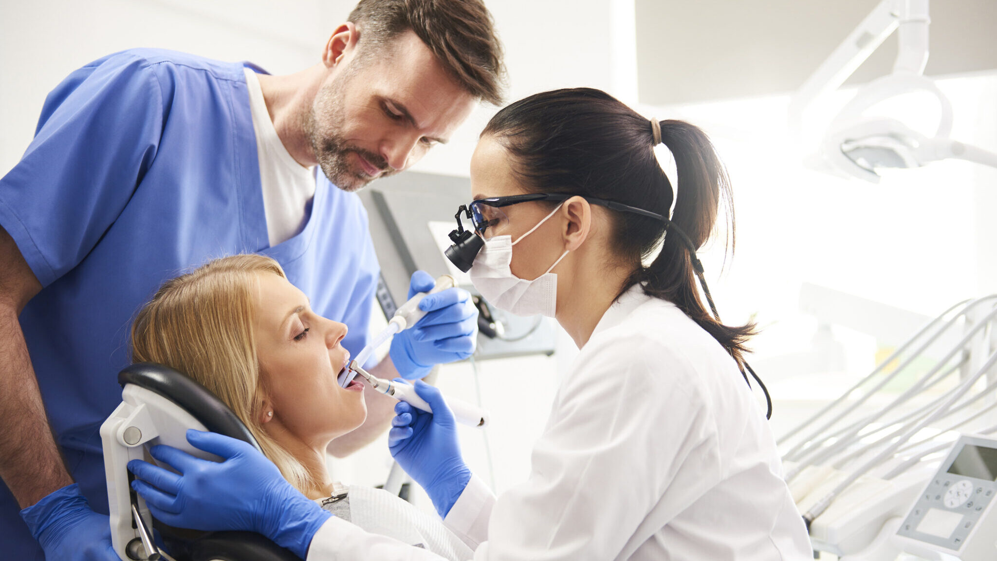 Dentist and her assistant doing their work in dentist’s clinic alternate text for this image
