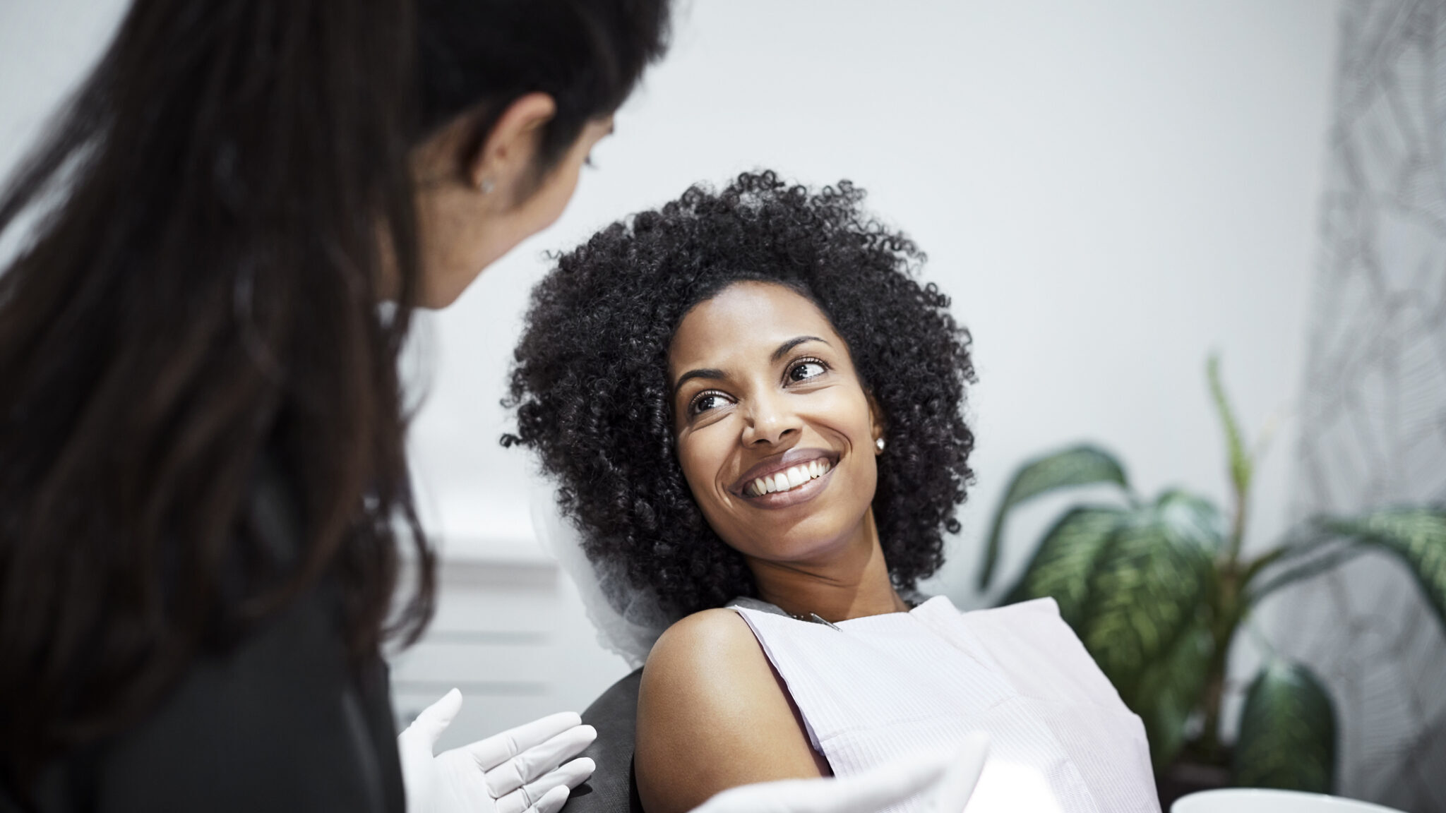 Dentist discussing with smiling female patient alternate text for this image