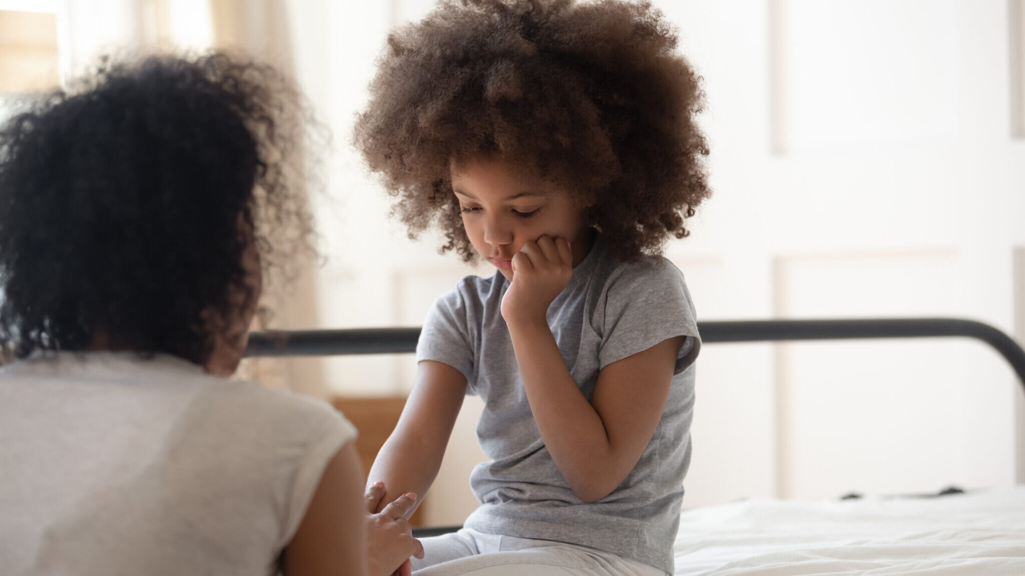African mother holds hand of little daughter talks gives support alternate text for this image