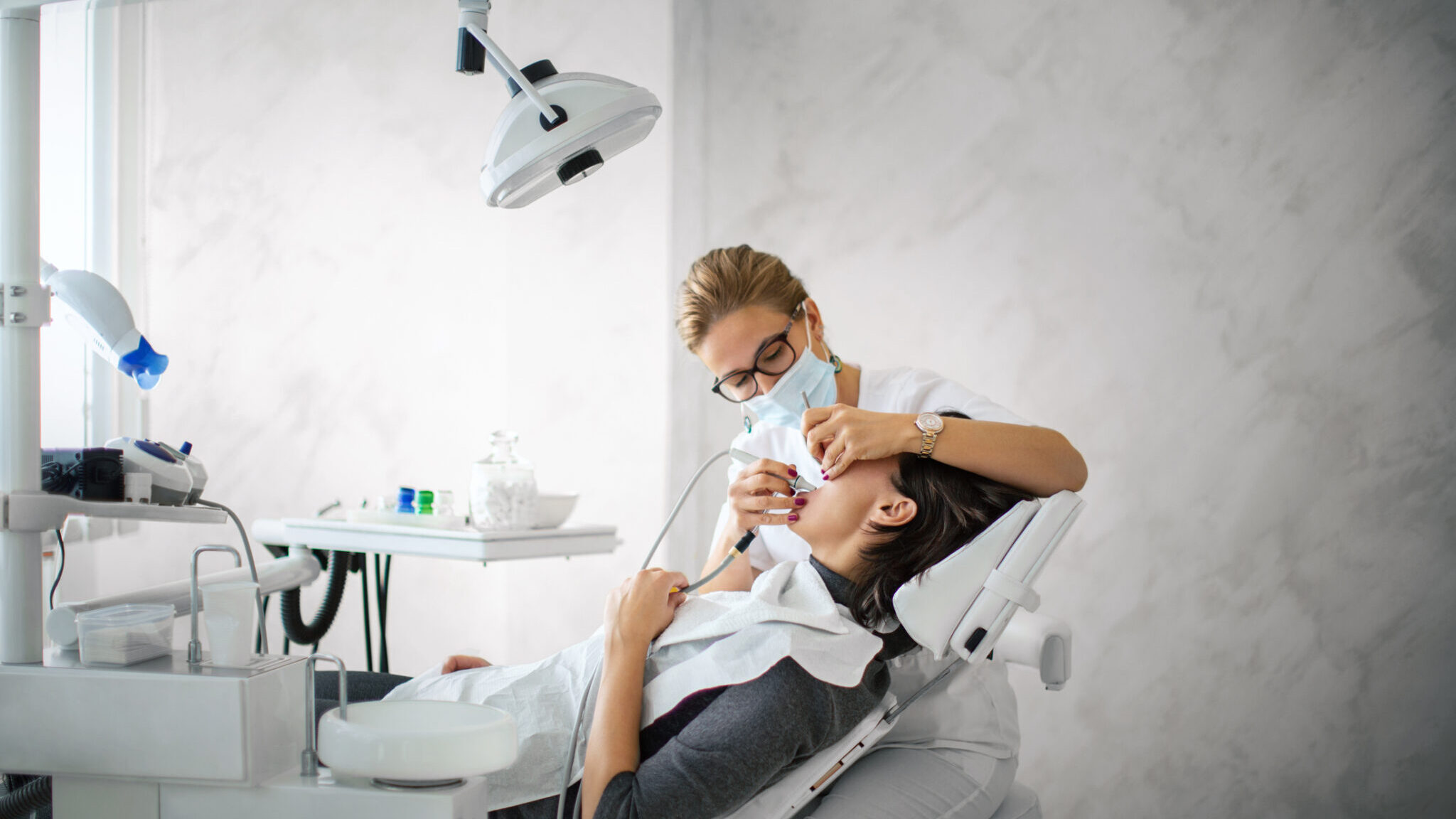 Dentist removing dental calculus. alternate text for this image