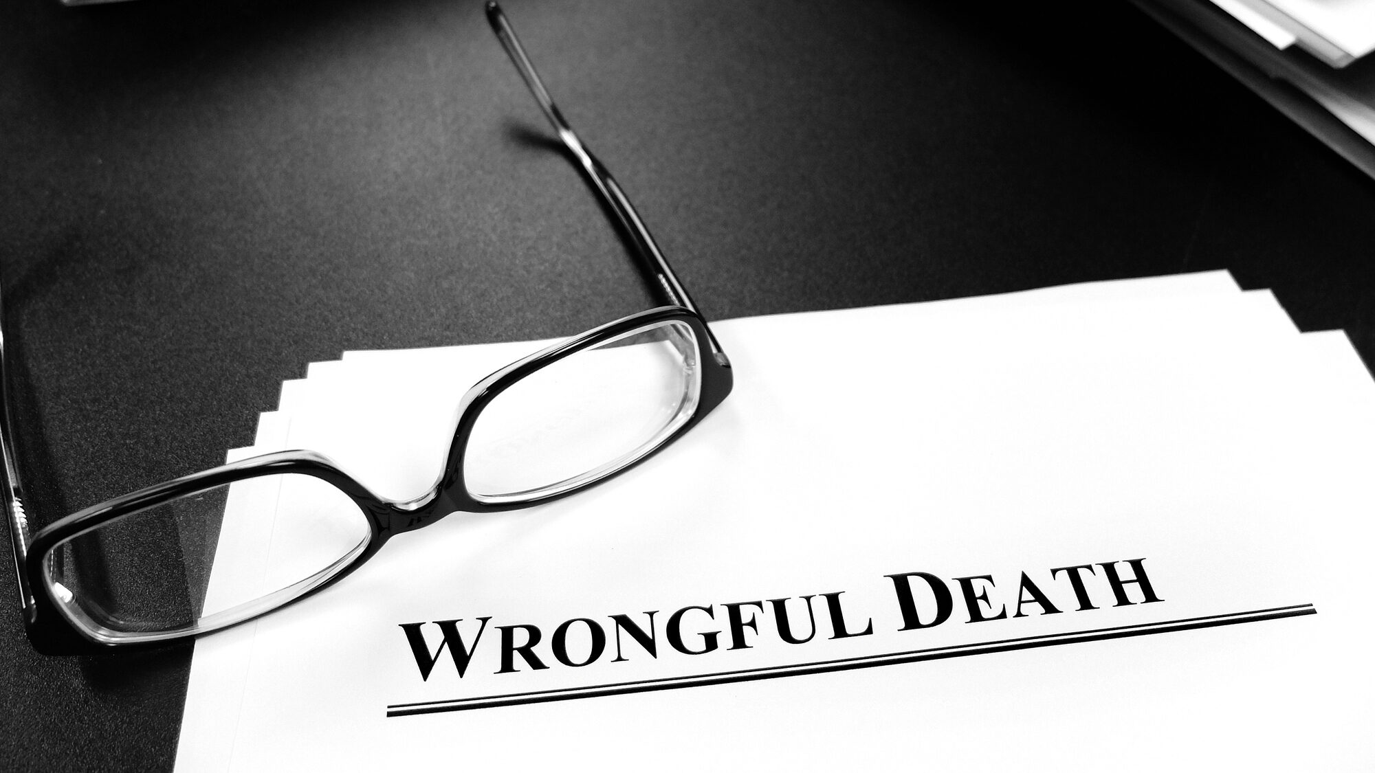 Wrongful Death Papers on Desk for Lawsuit with Glasses alternate text for this image