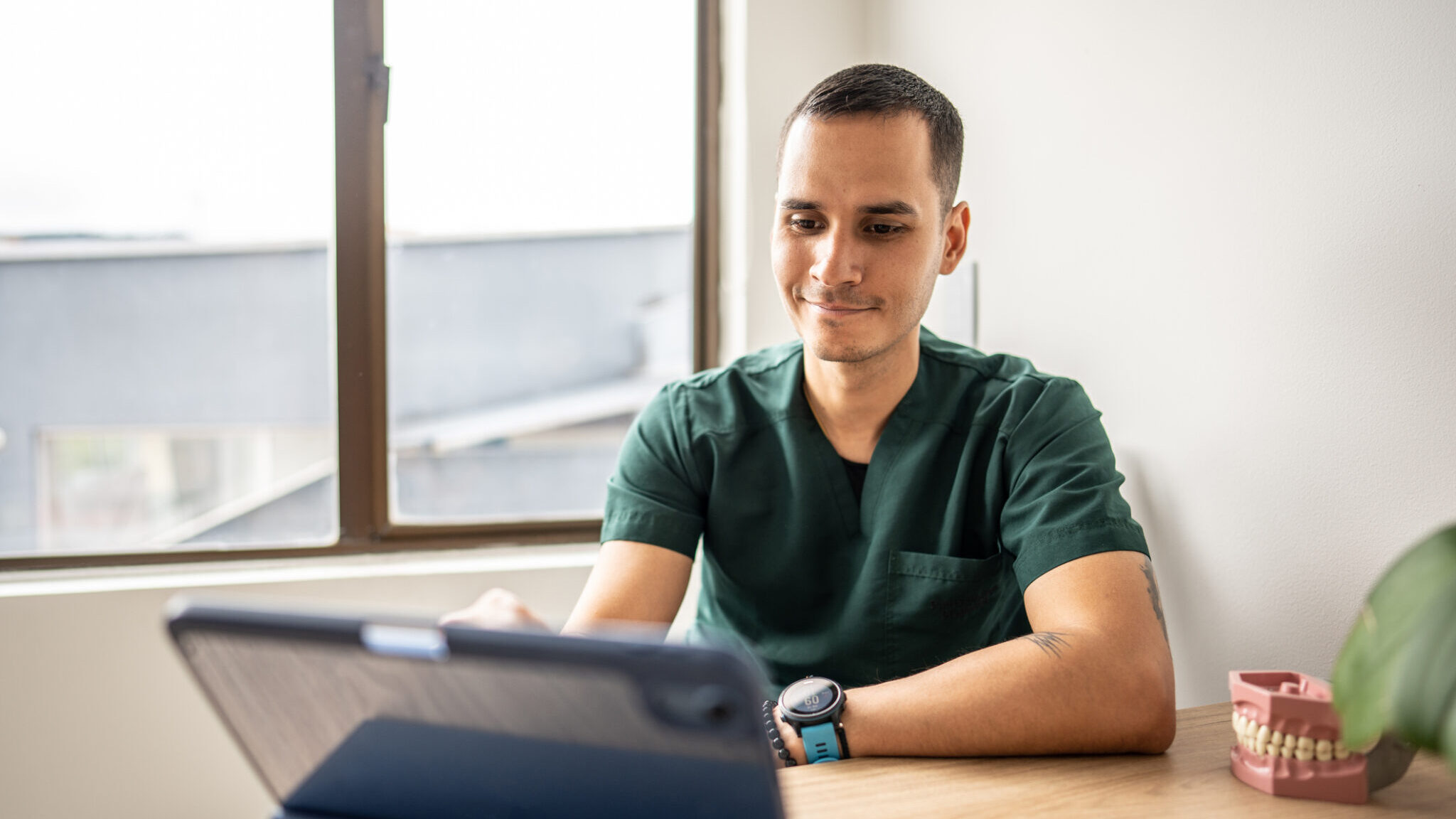 Mid adult dentist man using tablet at medica clinic alternate text for this image