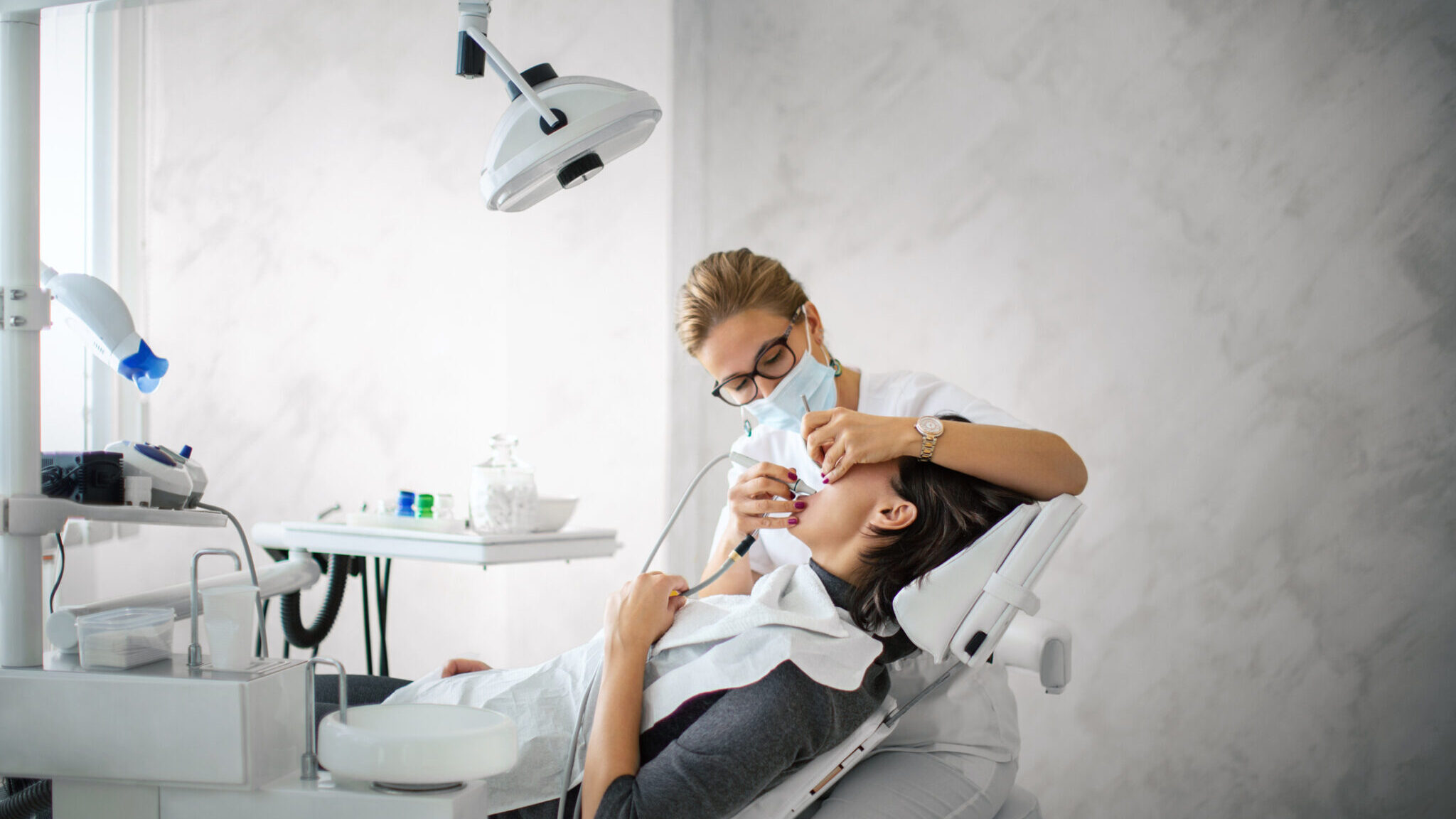 Dentist removing dental calculus. alternate text for this image