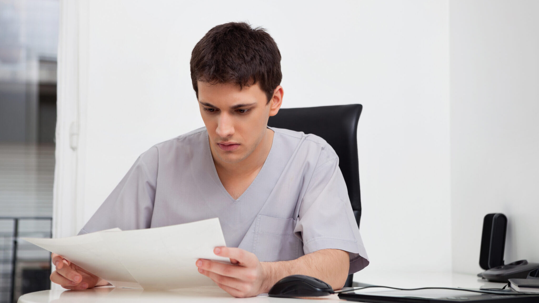 Doctor reading reports alternate text for this image