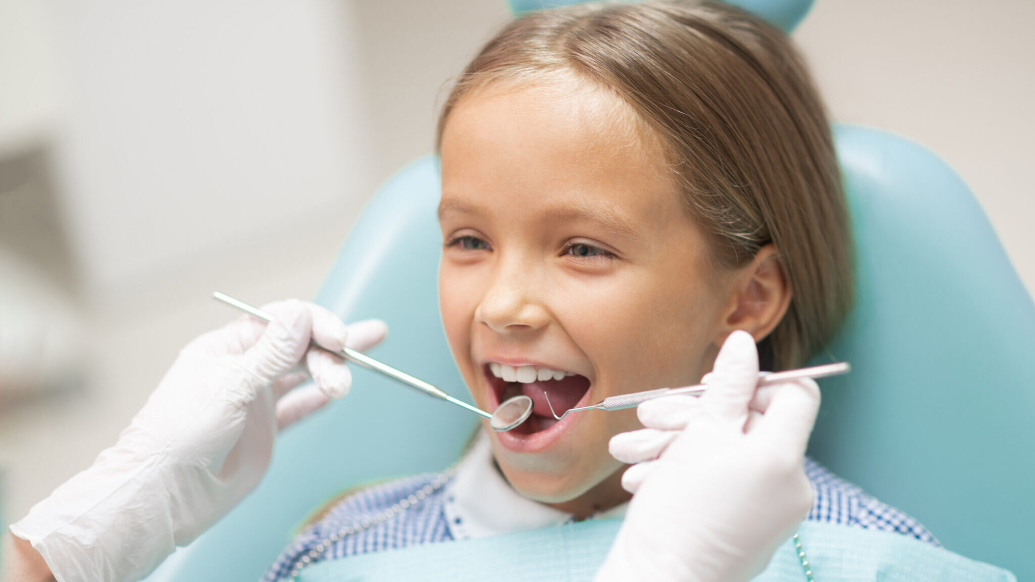 Cute girl smiling while visiting dentist at the weekend alternate text for this image