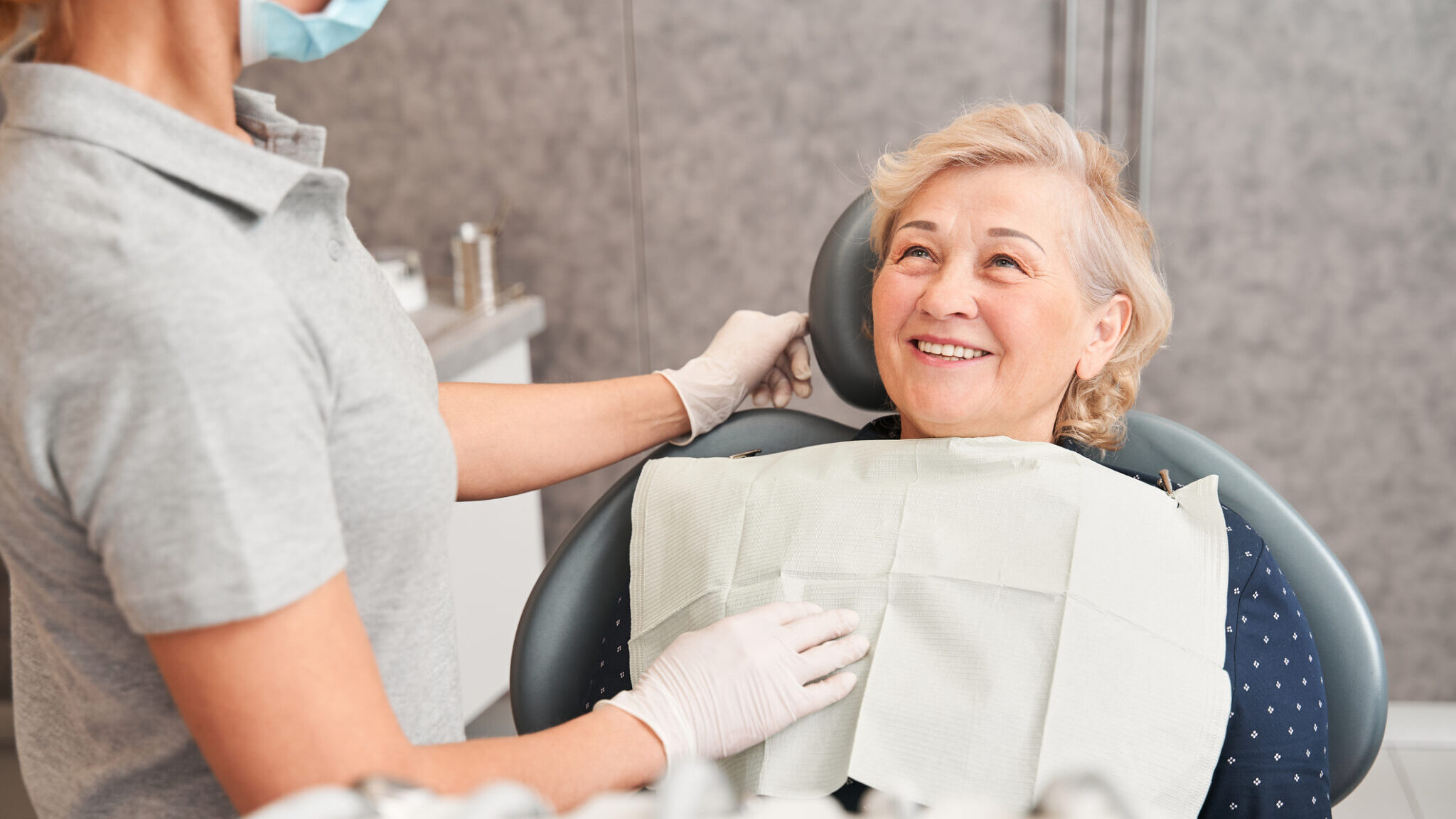 Woman sitting in dental chair and listening to dentist alternate text for this image