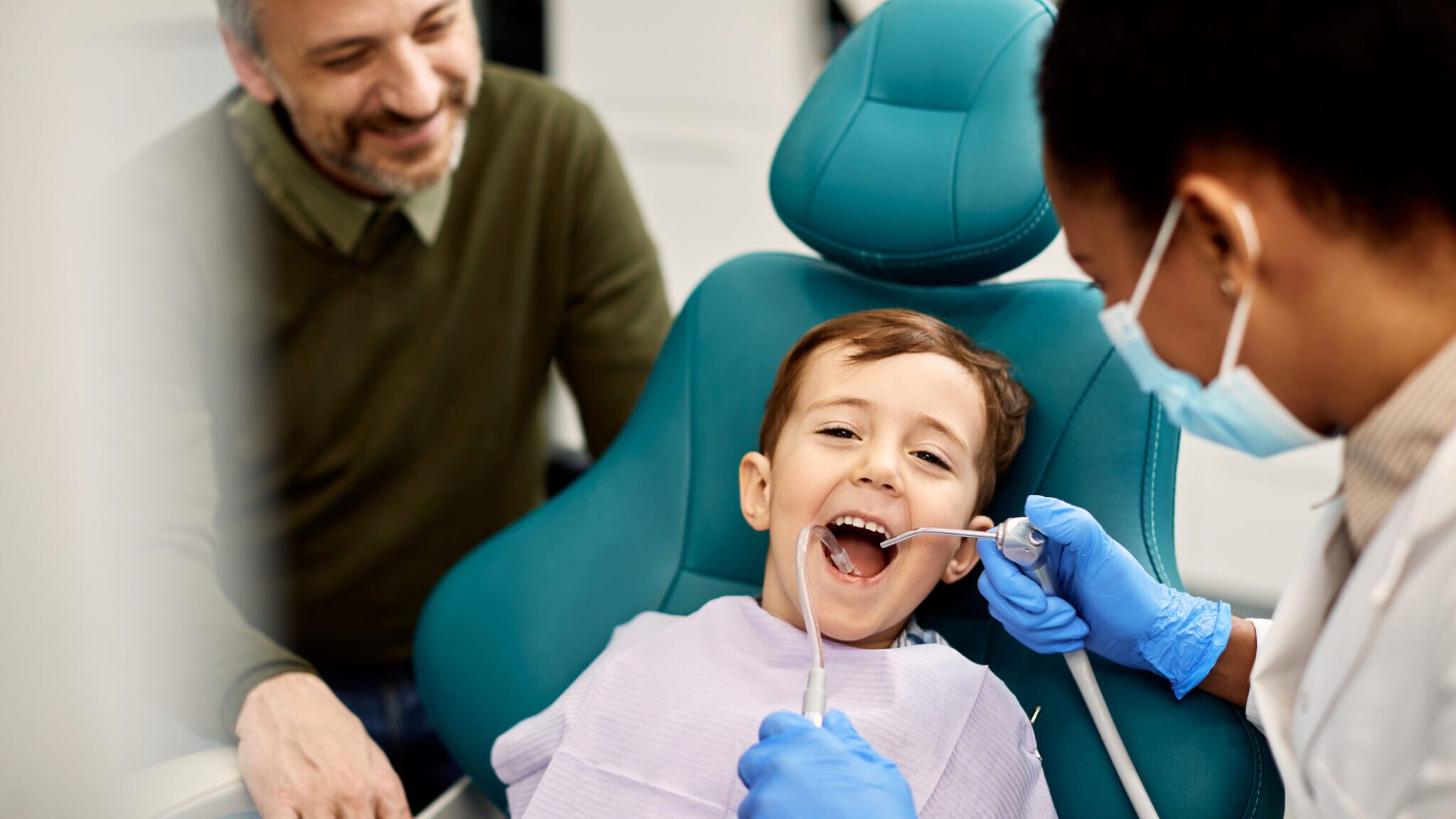 Happy boy having his teeth checked by female dentist. alternate text for this image