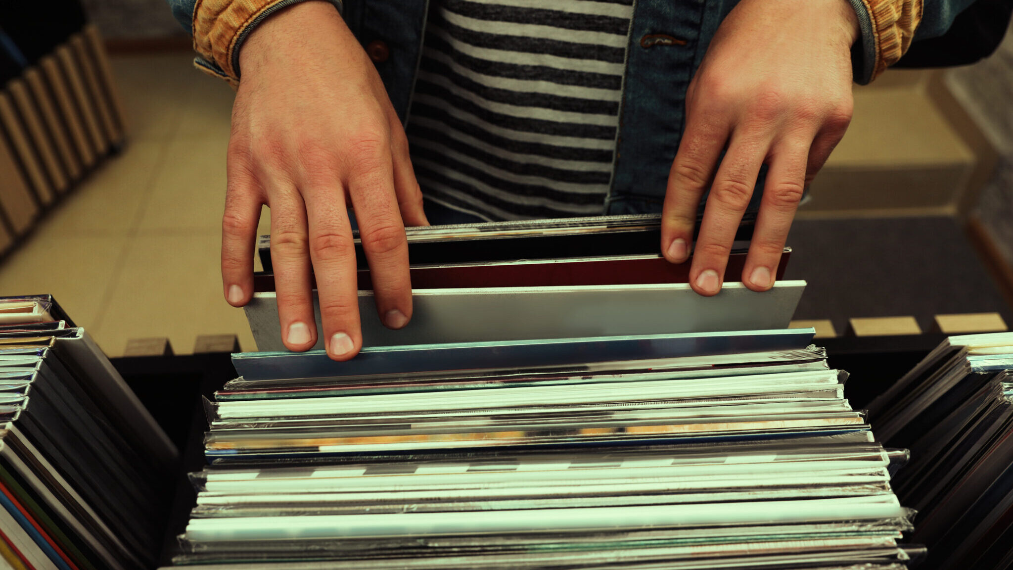 Man choosing vinyl records in store, closeup alternate text for this image