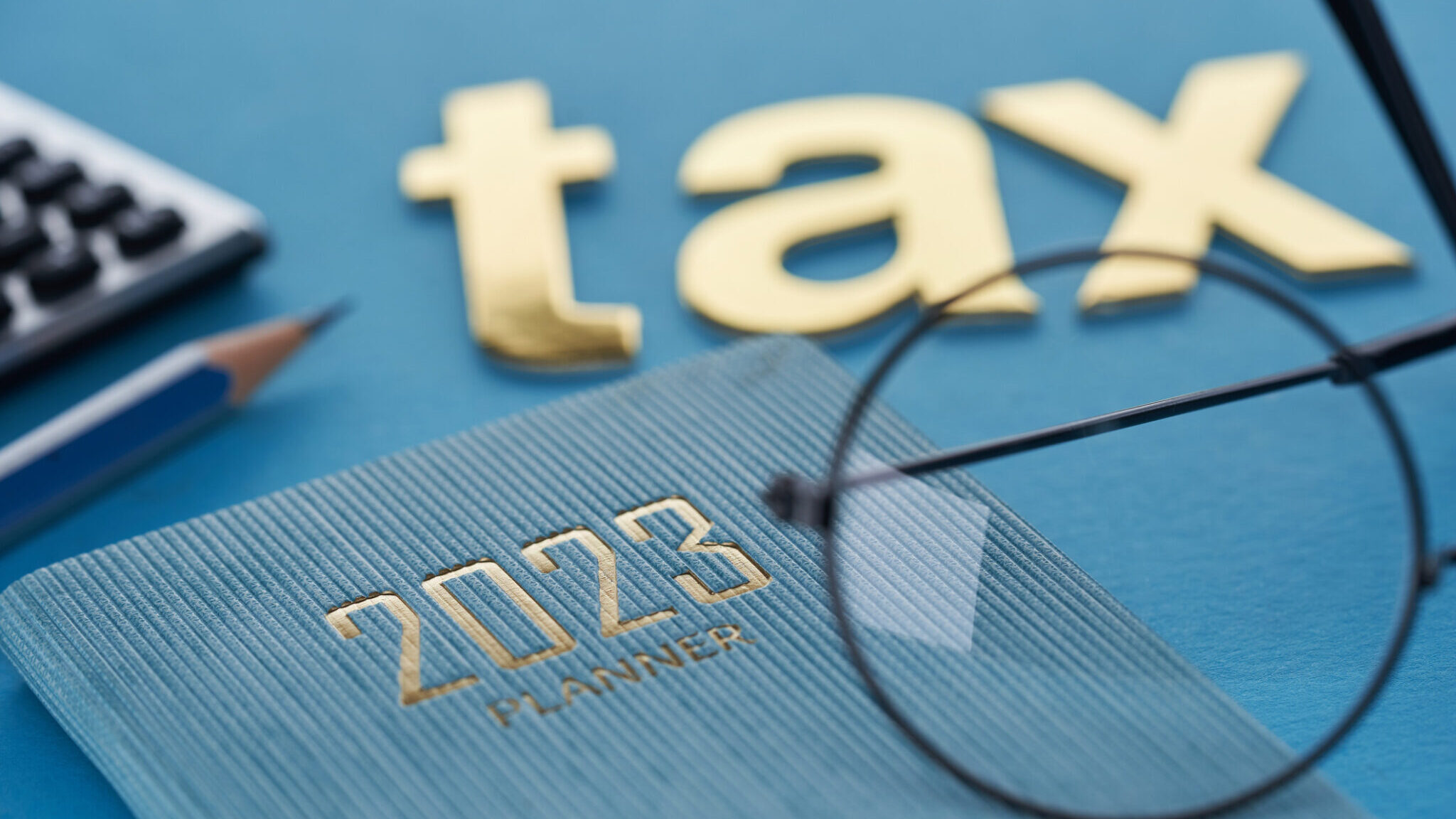 single word tax with 2023 calendar and calculator alternate text for this image