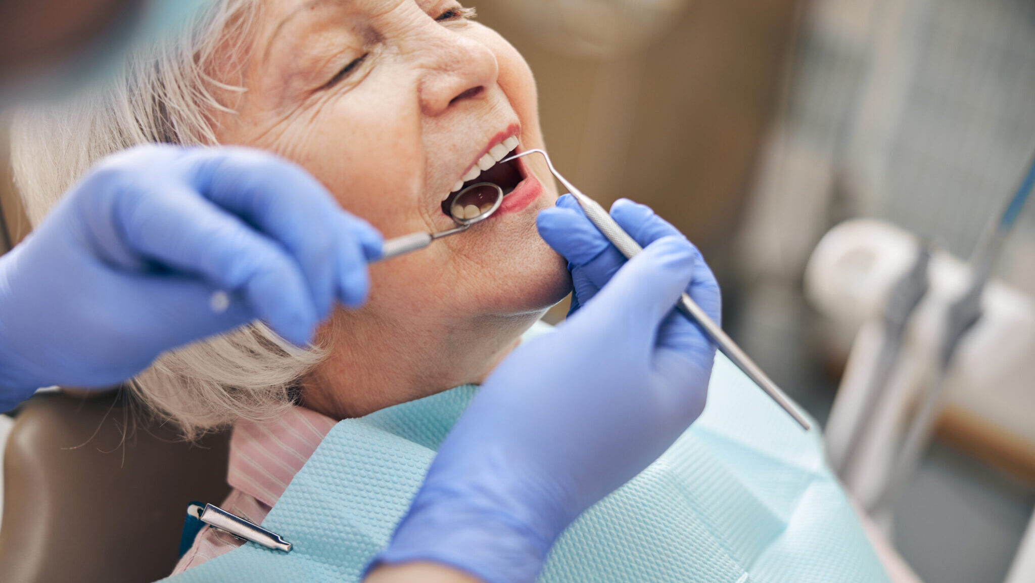 Vertical image of woman patient fixing her teeth in modern clinic alternate text for this image