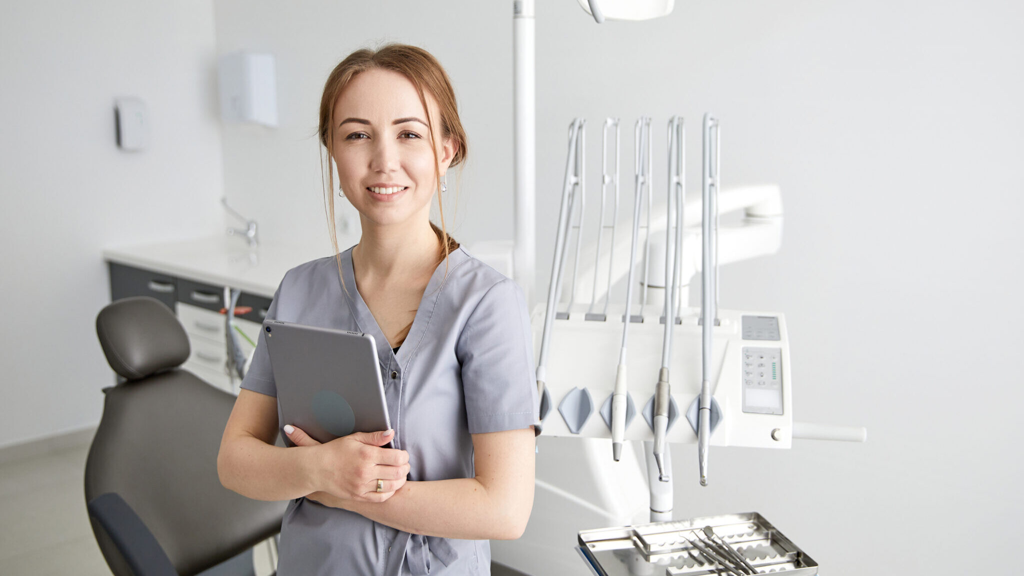 Young doctor in a dental clinic. Portrait of young female doctor dentist with digital tablet in dental office alternate text for this image