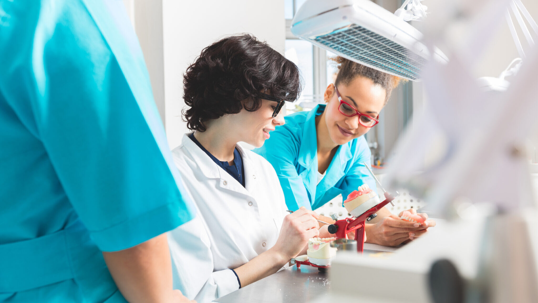 Multi ethnic female students learning prosthetic dentistry alternate text for this image