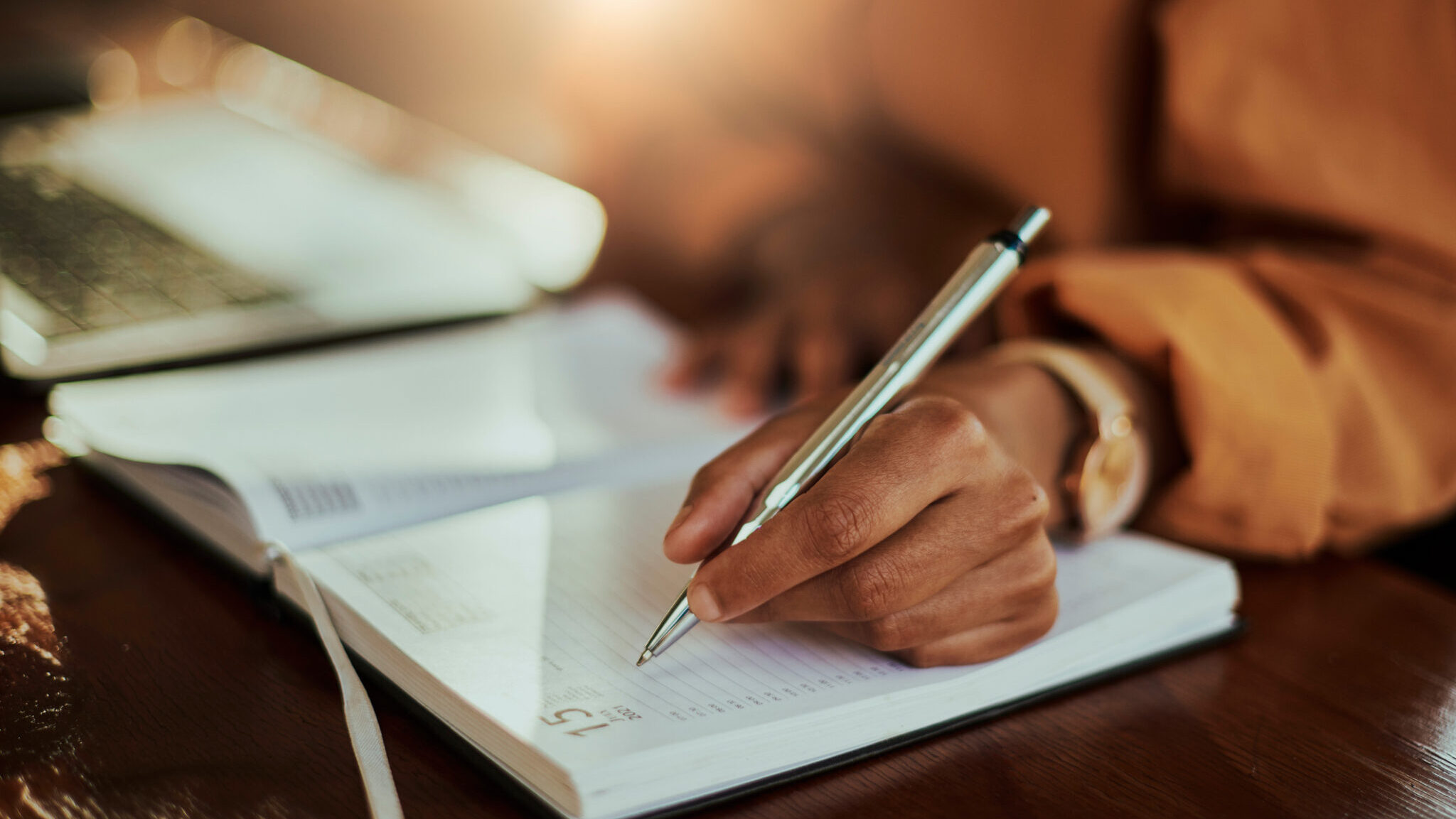 Reminder, schedule and hands writing in notebook for learning, education and working in home office. Study, creative and woman with an agenda, planner and scheduling to remember a plan in a diary alternate text for this image