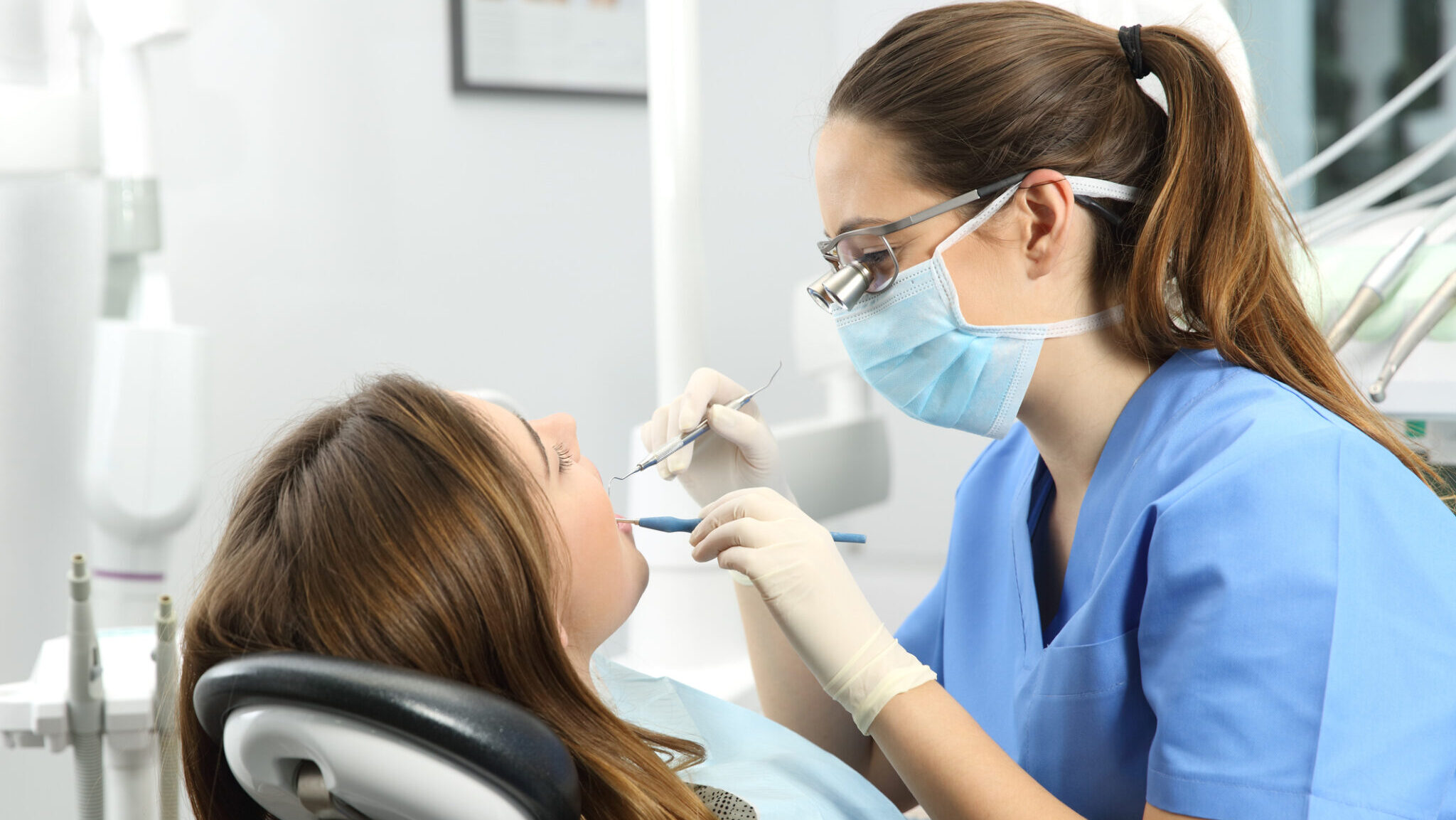 Dentist examining a patient teeth alternate text for this image