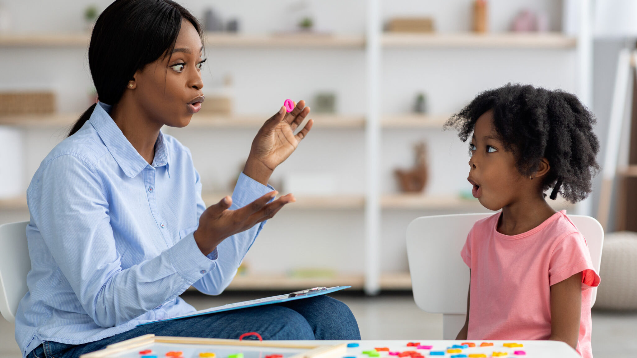 Speech therapist working with little black girl alternate text for this image
