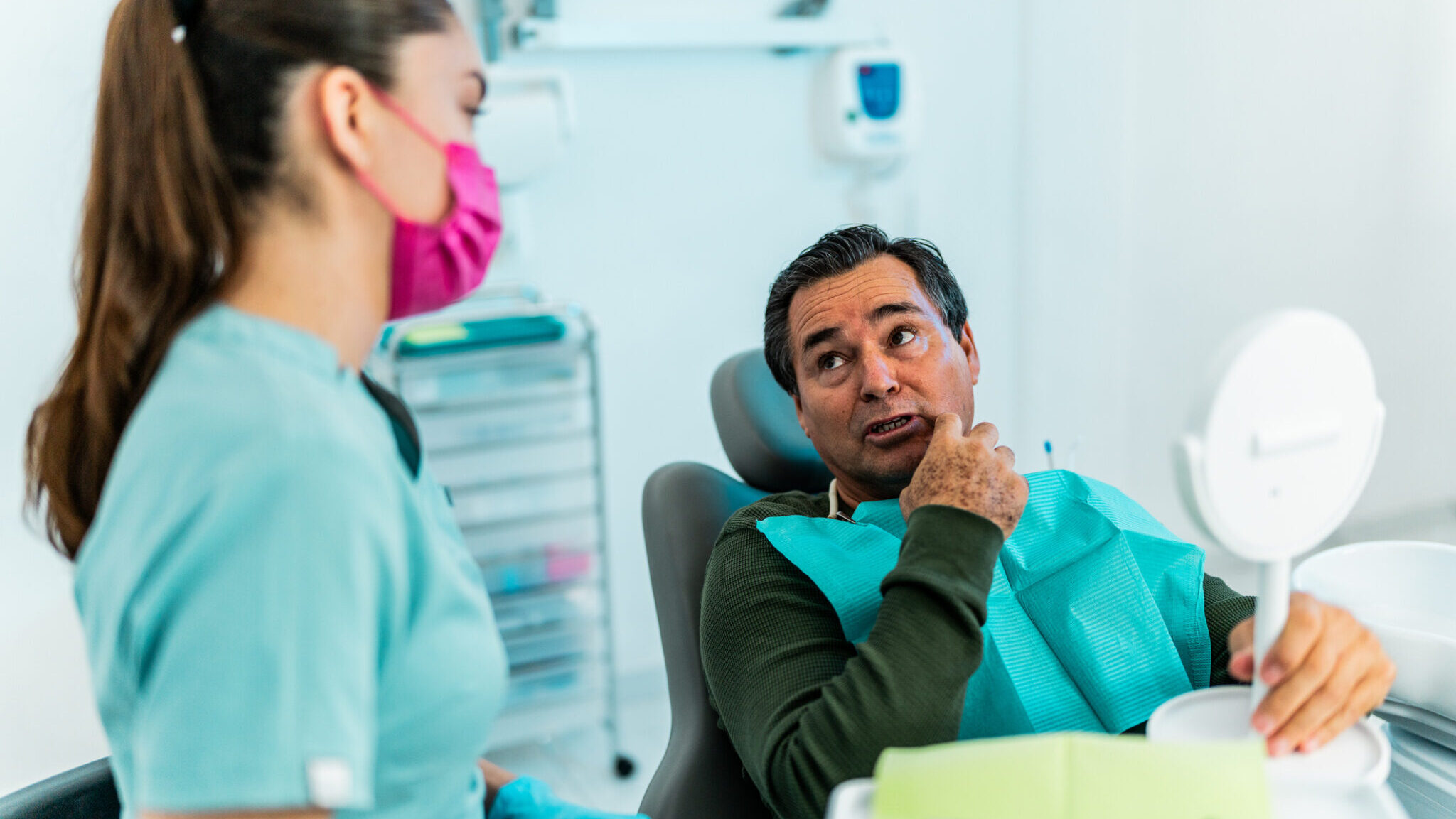 Senior patient man talking with dentist at dentist’s office alternate text for this image