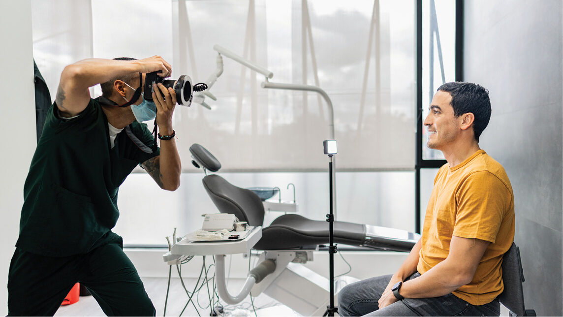 Man taking a photo of another man at a dental office