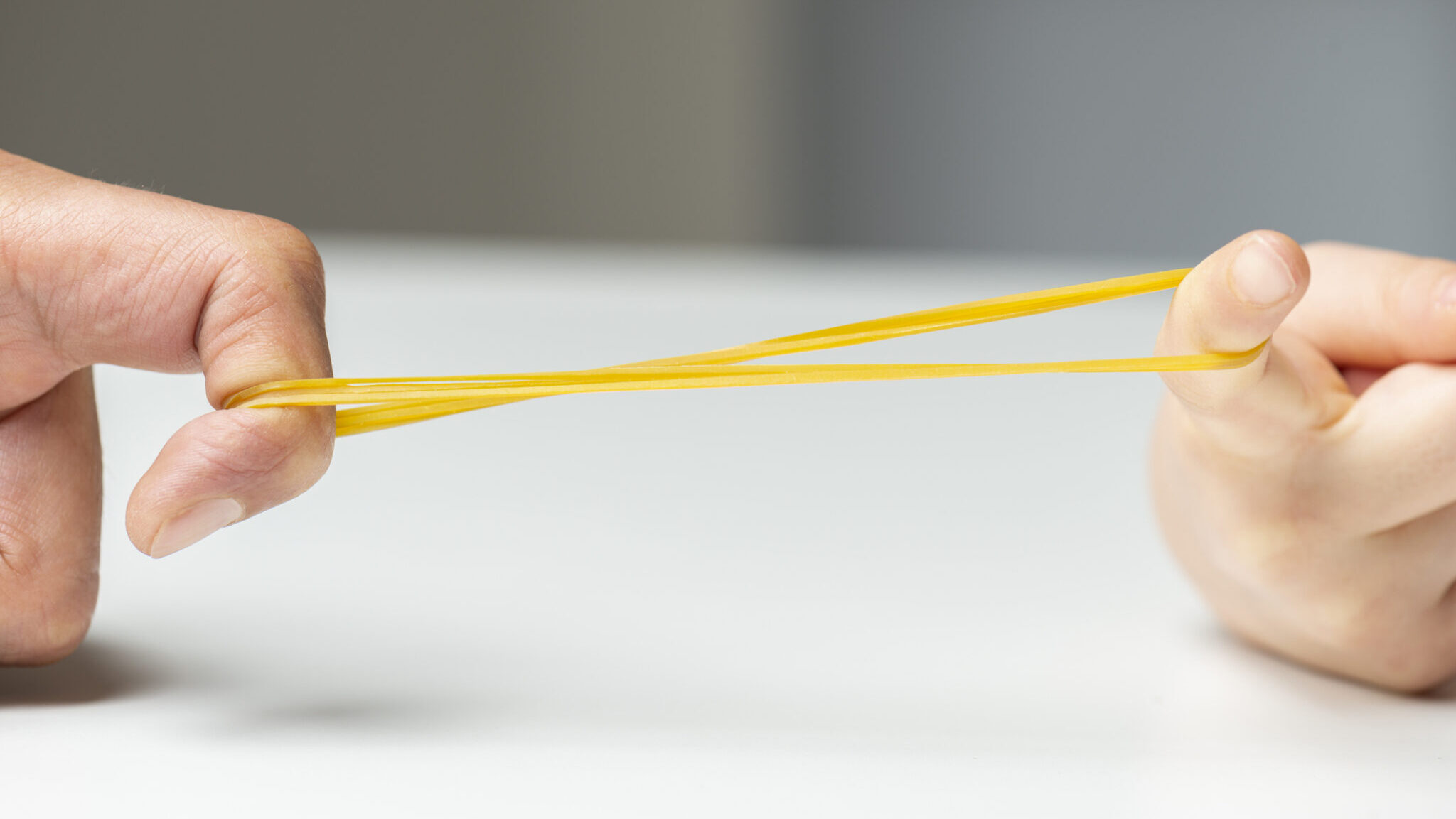 Father and her daughter are pulling rubber band. Close-up.