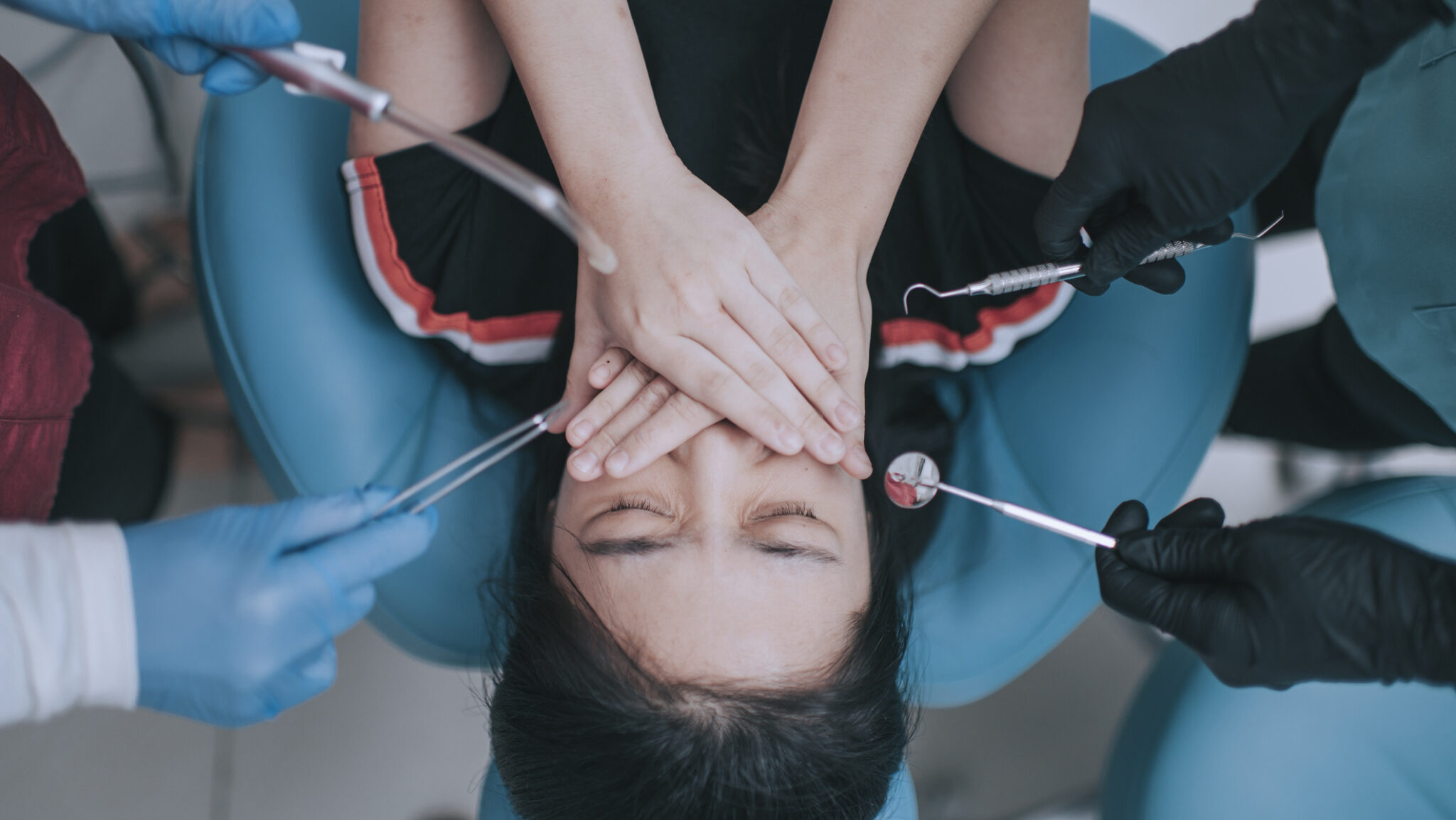 directly above Dental examination inspection on chinese teenage girl covering mouth