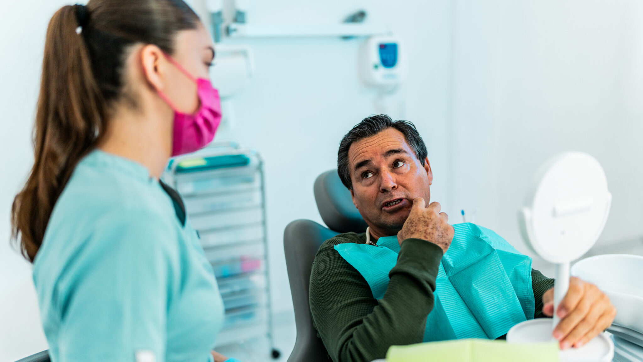 Senior patient man talking with dentist at dentist's office