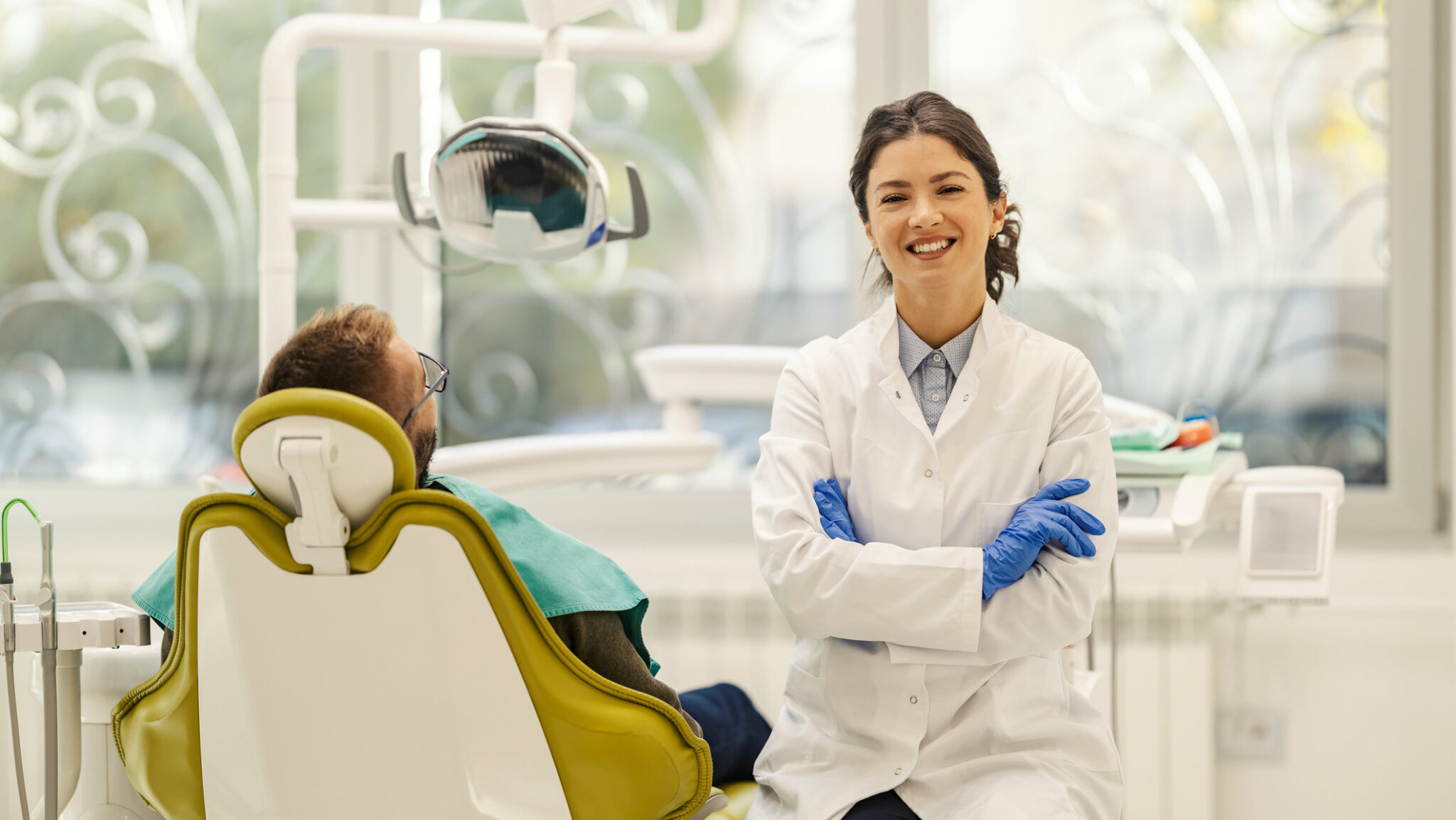 Portrait of confident dentist at dentist office with arms crossed during appointment. alternate text for this image