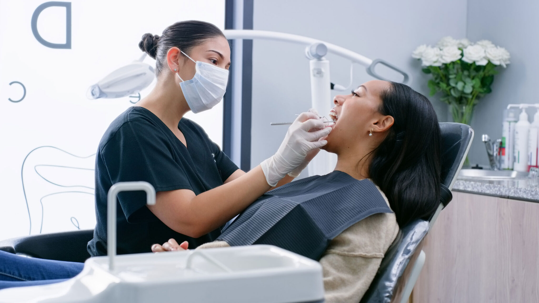 Dentist, woman and patient with tools for teeth whitening, oral hygiene and consultation with mask. Healthcare, specialist and person for mouth wellness, dental service and check for gum bacteria