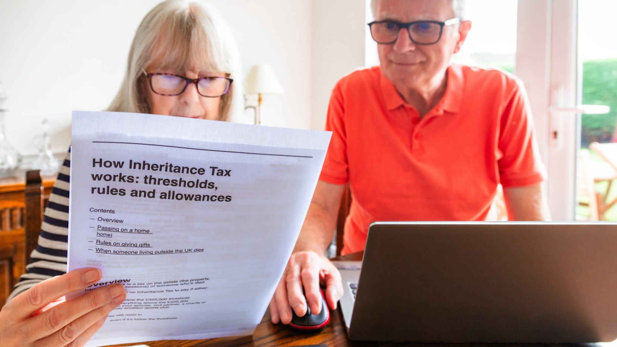 Worried senior couple looking at inheritance tax documents at home alternate text for this image