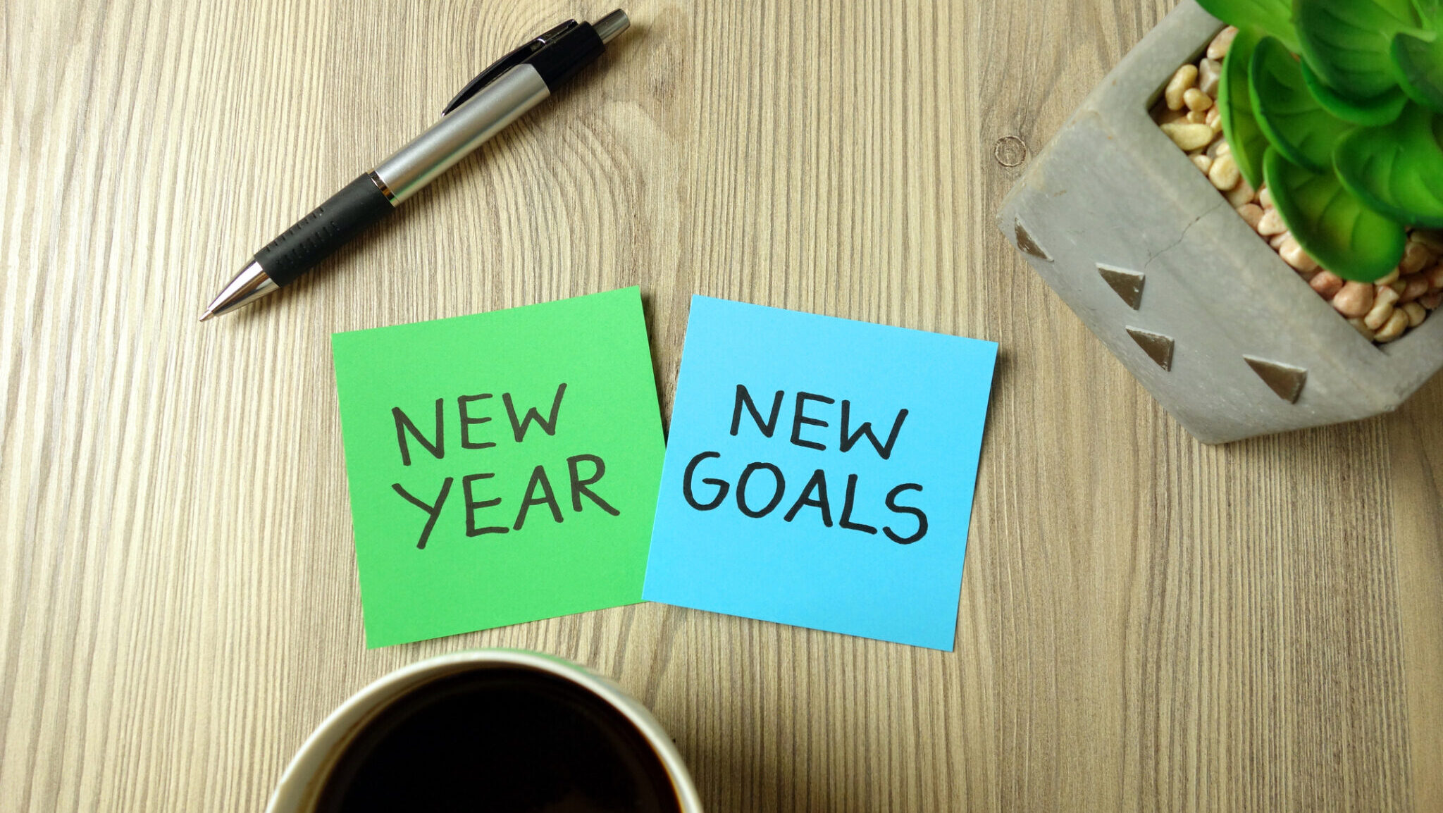 New Year goals concept with text handwritten on sticky notes in office